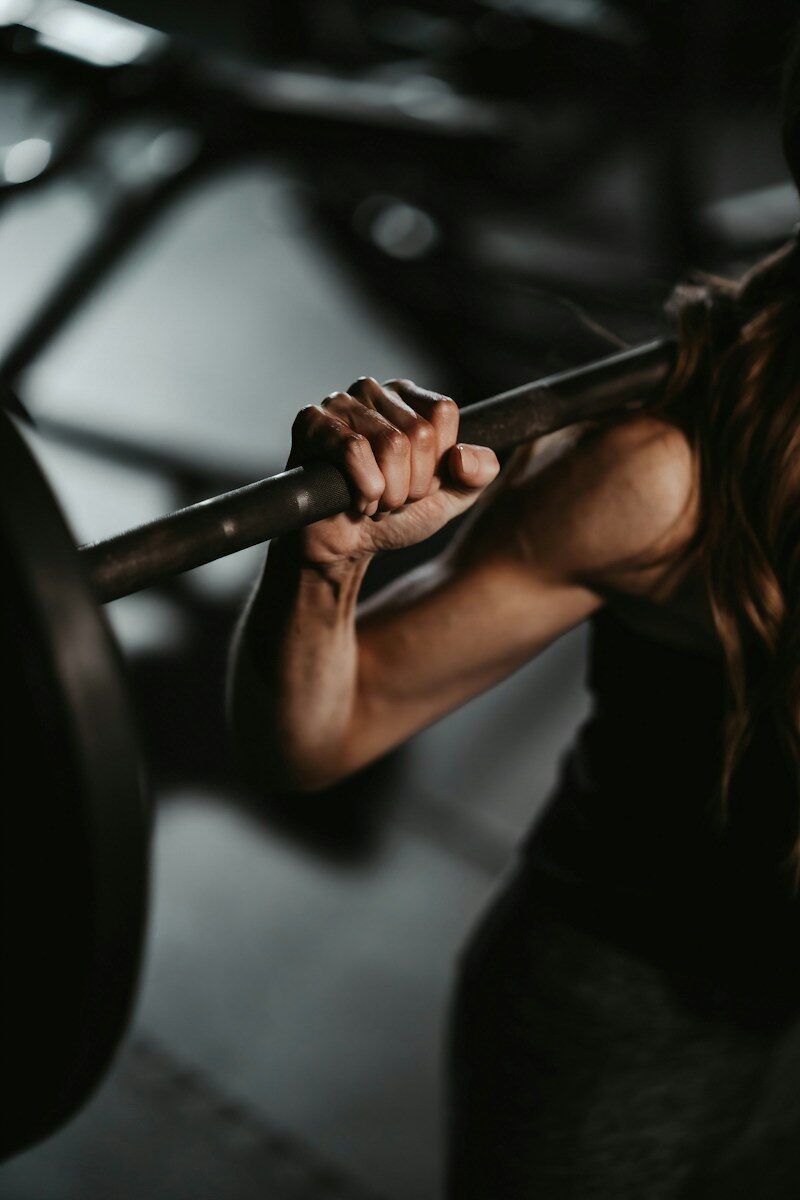 IV Drips 1 A woman lifting a barbell in a gym